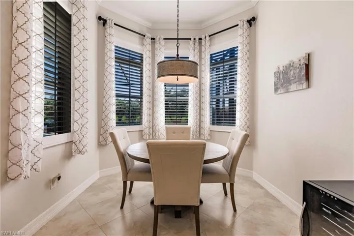 Dining area featuring ornamental molding and light tile floors