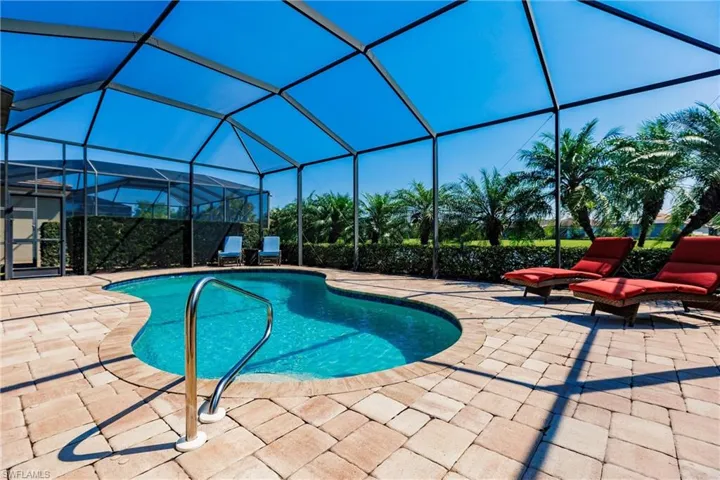 View of pool with a patio and glass enclosure