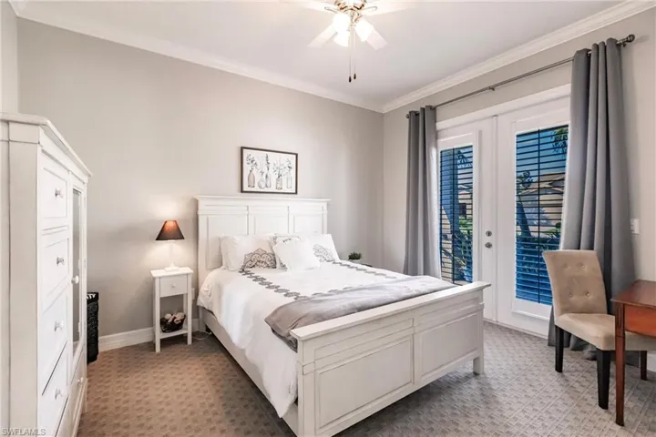 Carpeted bedroom featuring ornamental molding, ceiling fan, french doors, and access to outside