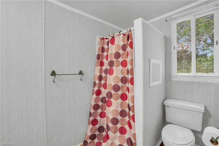 Bathroom featuring ornamental molding, a wealth of natural light, and toilet