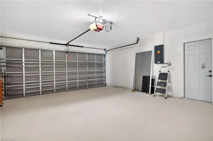 Garage featuring electric panel and a garage door opener