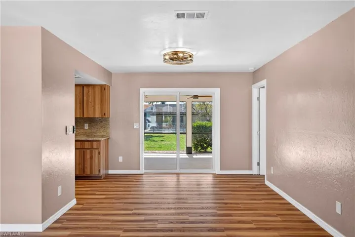 Dining area featuring sliding doors to screened lanai.  Door to right is Primary Bedroom