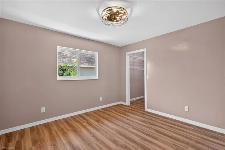Bedroom 2 featuring walk in closet and new fan/light fixture across from guest bathroom