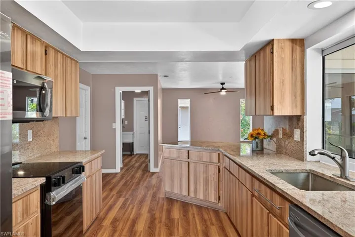 Galley kitchen with new granite counters, plenty of cabinets and brand new stainless steel appliances