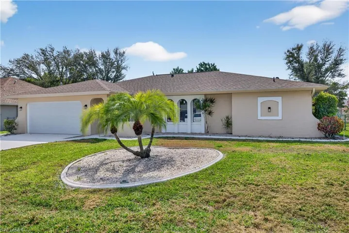 Single story home featuring an attached garage, a front lawn, concrete driveway, stucco siding, and a shingled roof