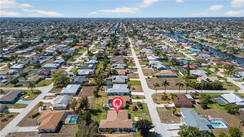 Aerial view of property and surrounding area featuring nearby suburban area