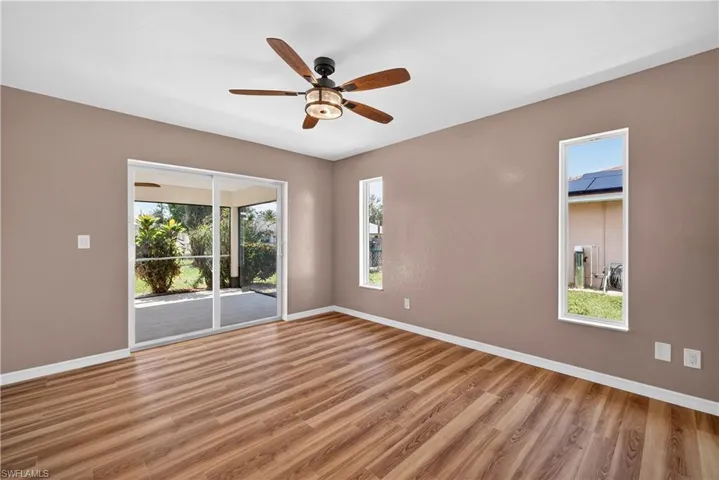 Primary bedroom with new sliding doors to screen lanai and new ceiling fan/light