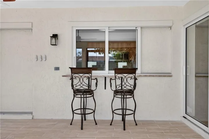 View of kitchen pass through window and bar seating