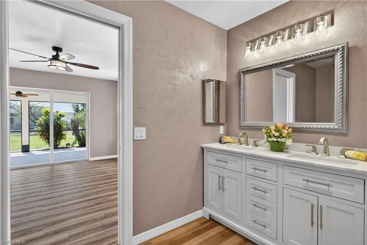 Primary bathroom with view of bedroom sliding doors to screened patio.
