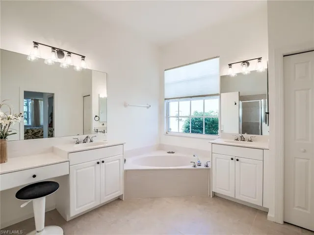Bathroom featuring shower with separate bathtub, tile patterned flooring, and double sink vanity