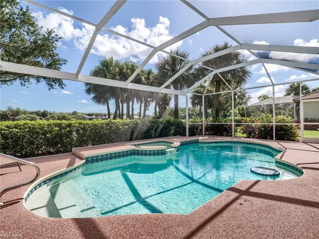 View of swimming pool featuring an in ground hot tub and a lanai