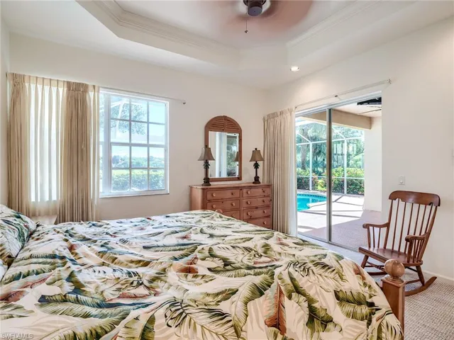 Bedroom featuring crown molding, access to exterior, ceiling fan, a raised ceiling, and carpet