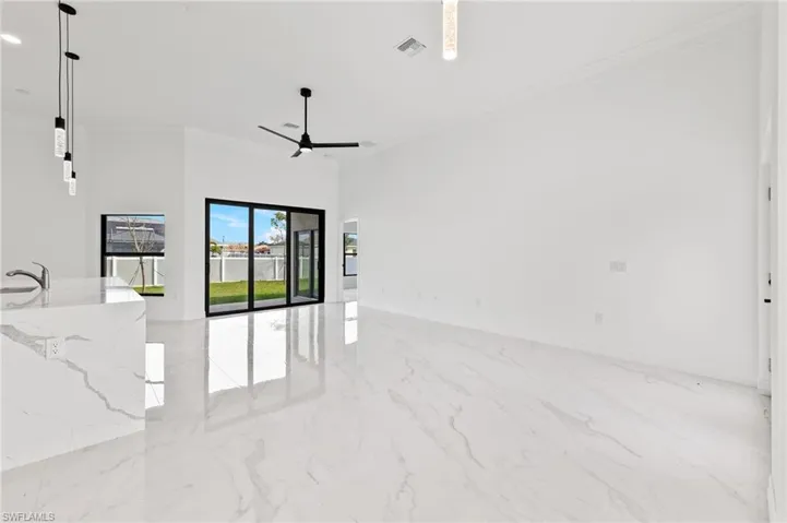 Unfurnished room with ornamental molding, light marble finish floors, and ceiling fan