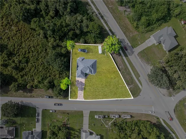 Property with a perimeter boundary, a paved driveway, and a shingled roof