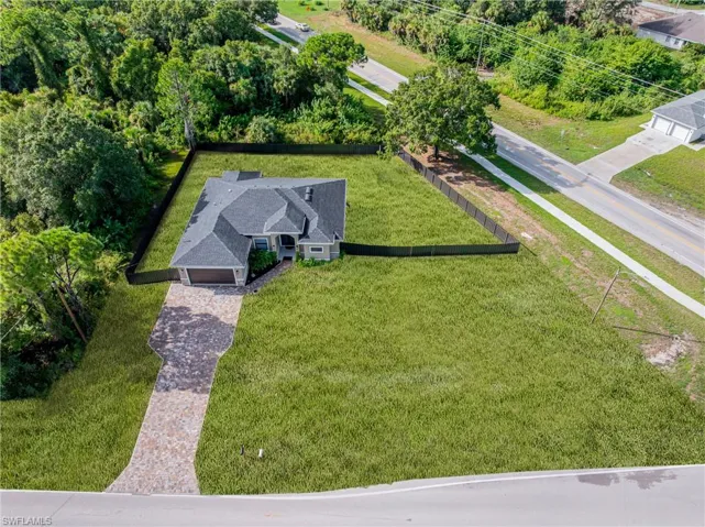 Elegant brick residence situated on expansive grounds featuring mature landscaping and tree-lined perimeter