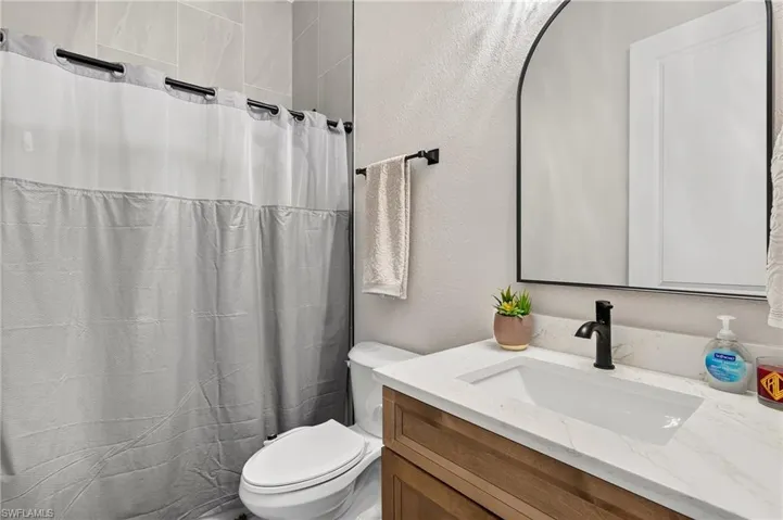 Integrated vanity with a rectangular sink, quartz countertop, and black-finish faucet
