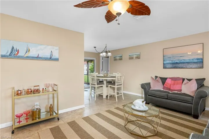 Living room with a ceiling fan, a chandelier, and light tile patterned flooring