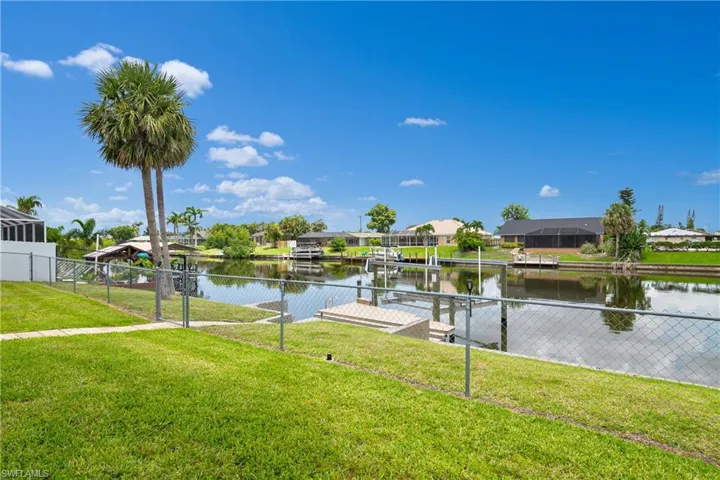 Dock featuring boat lift, a residential view, and a water view