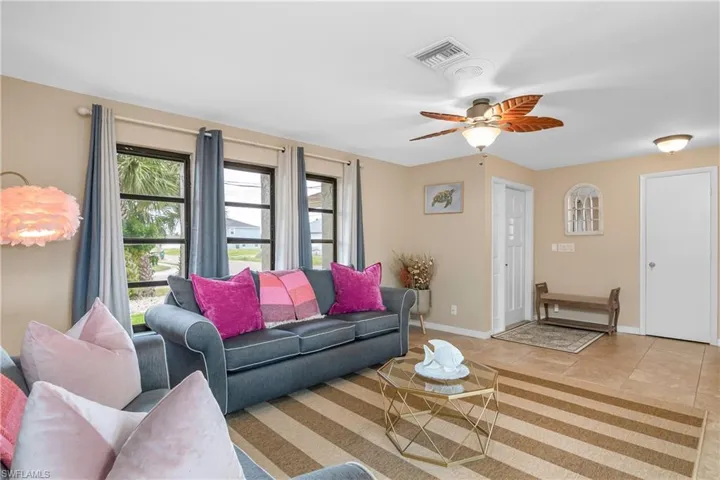 Living area featuring a ceiling fan and light tile patterned flooring
