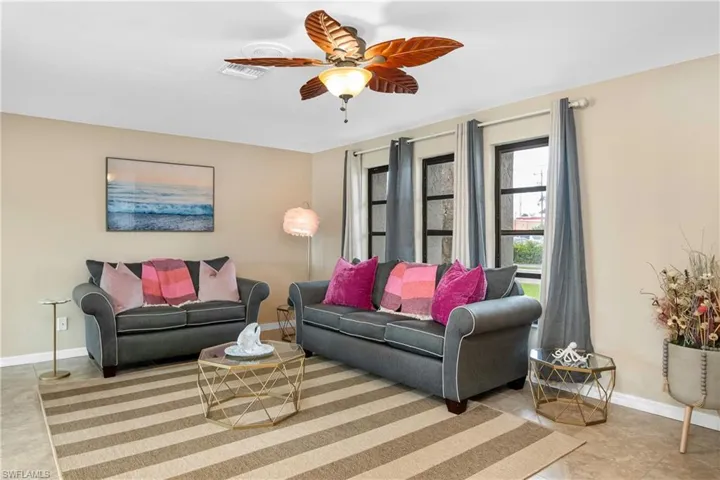 Living area featuring baseboards and a ceiling fan