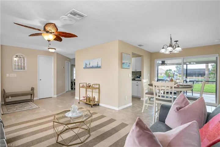 Living area featuring a ceiling fan, a chandelier, and light tile patterned floors