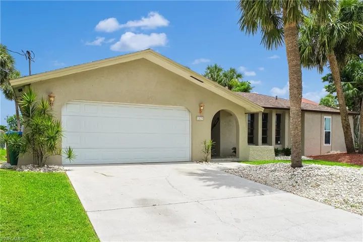 Ranch-style house with stucco siding, driveway, and a garage