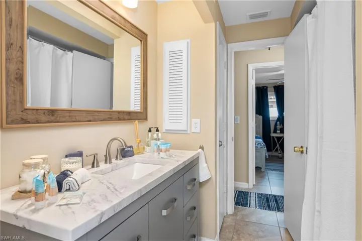 Bathroom featuring a shower with curtain, vanity, and light tile patterned floors