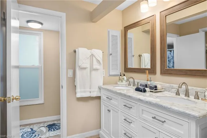 Bathroom with double vanity and curtained shower