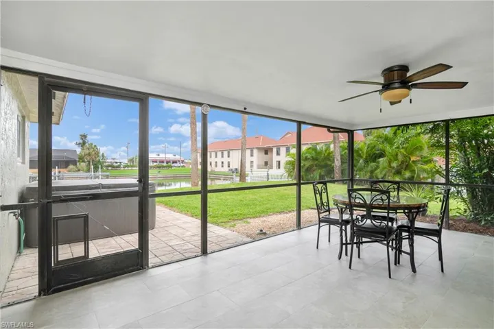 Sunroom / solarium featuring a water view, outdoor dining space, and ceiling fan