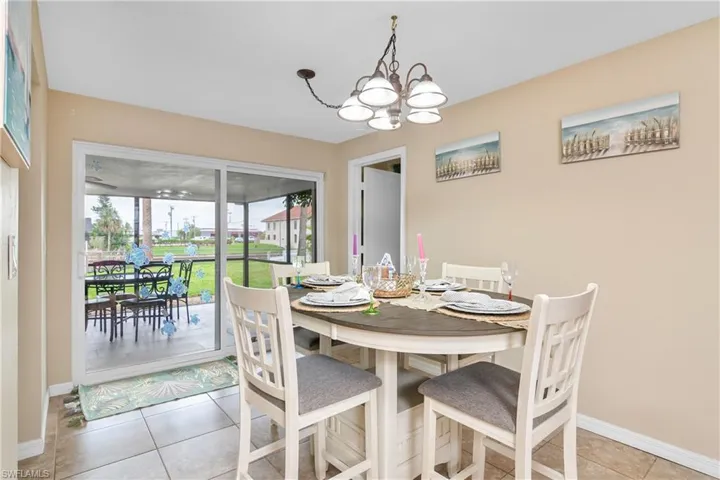 Dining room with light tile patterned floors and a chandelier