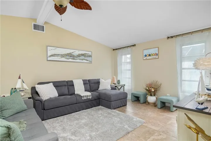 Living area featuring ceiling fan and light tile patterned floors