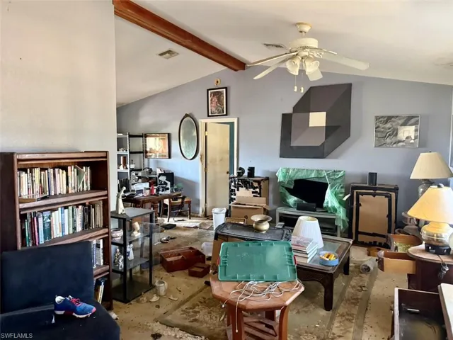 Living area featuring beam ceiling and a ceiling fan