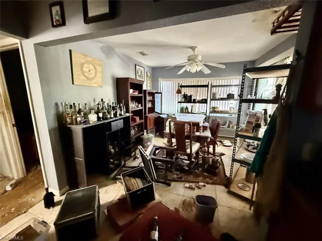 Dining area with a ceiling fan, light tile patterned floors, and a dry bar