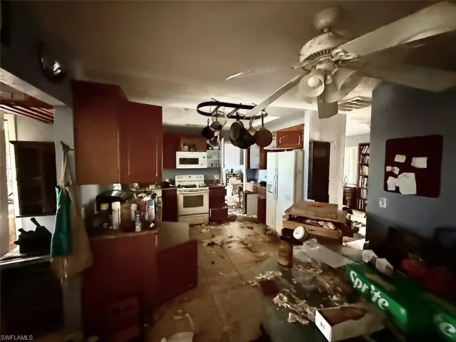 Kitchen featuring white appliances, a ceiling fan, and dark countertops