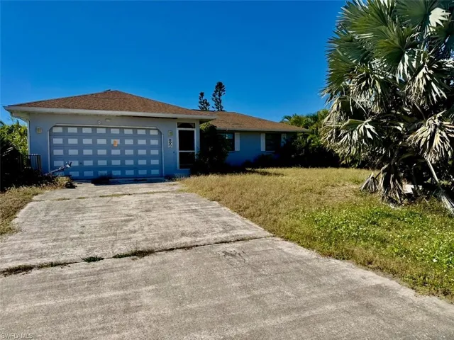 Ranch-style house featuring concrete driveway, an attached garage, stucco siding, and a front yard