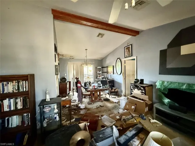 Living area with a chandelier and vaulted ceiling with beams