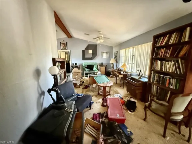 Sitting room with lofted ceiling with beams and a ceiling fan