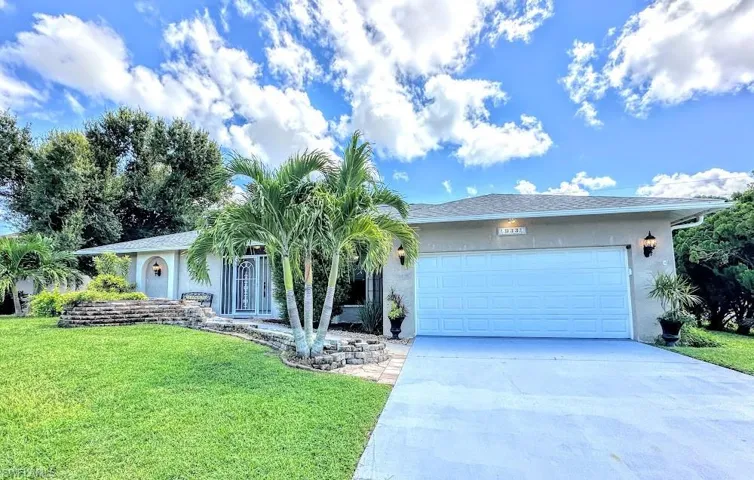 Ranch-style house with a front yard and a garage and water feature