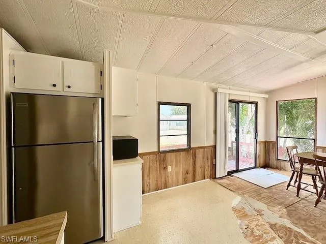 Kitchen featuring stainless steel fridge and white cabinets
