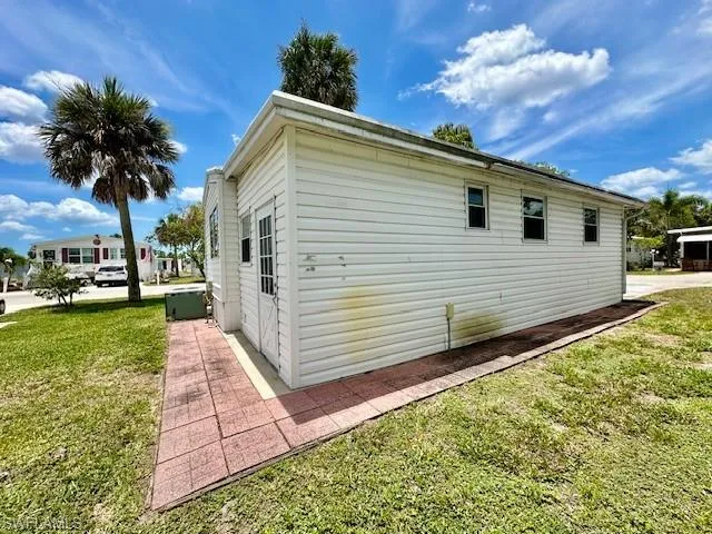 View of side of property with a lawn