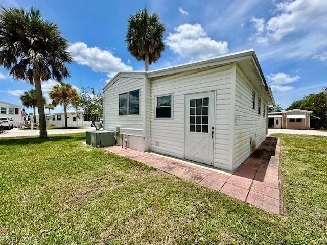 Back of house featuring an outdoor structure, a lawn, and a garage