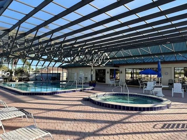 View of pool with a patio area and a hot tub