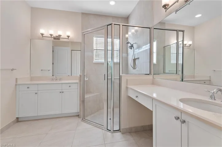 Primary Bathroom featuring dual vanity, tile  flooring, and a shower