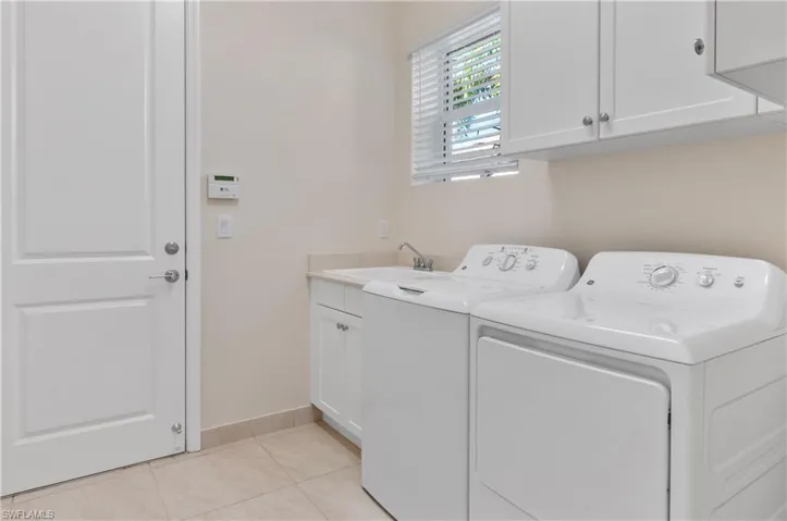 Laundry Room with cabinets, washer/dryer, and sink