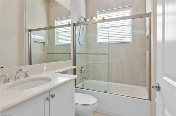 Full bathroom with bath / shower combo with glass door, and vanity