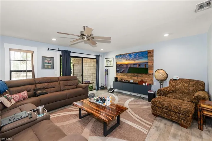 Living area featuring light wood finished floors, ceiling fan, and recessed lighting