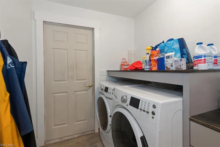 Laundry area with washer and dryer and light wood finished floors