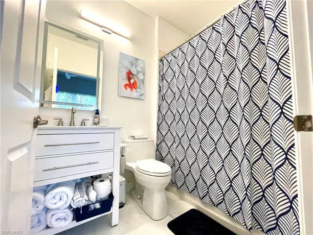 Bathroom featuring vanity and shower / bath combination with curtain