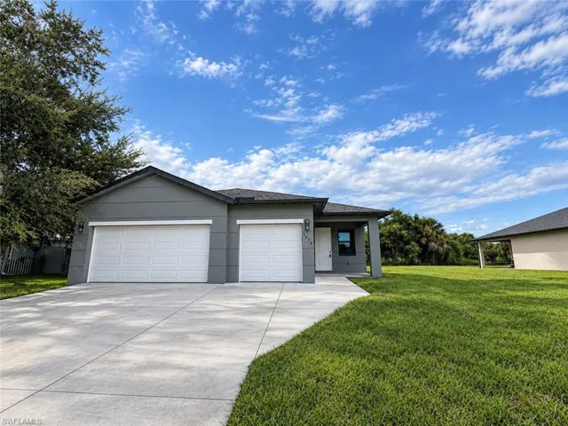 Contemporary single-story residence featuring a two-car garage, gray exterior siding, covered entryway, and a concrete driveway