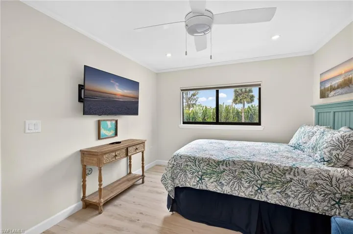 Bedroom with light wood-type flooring, ornamental molding, a ceiling fan, and recessed lighting